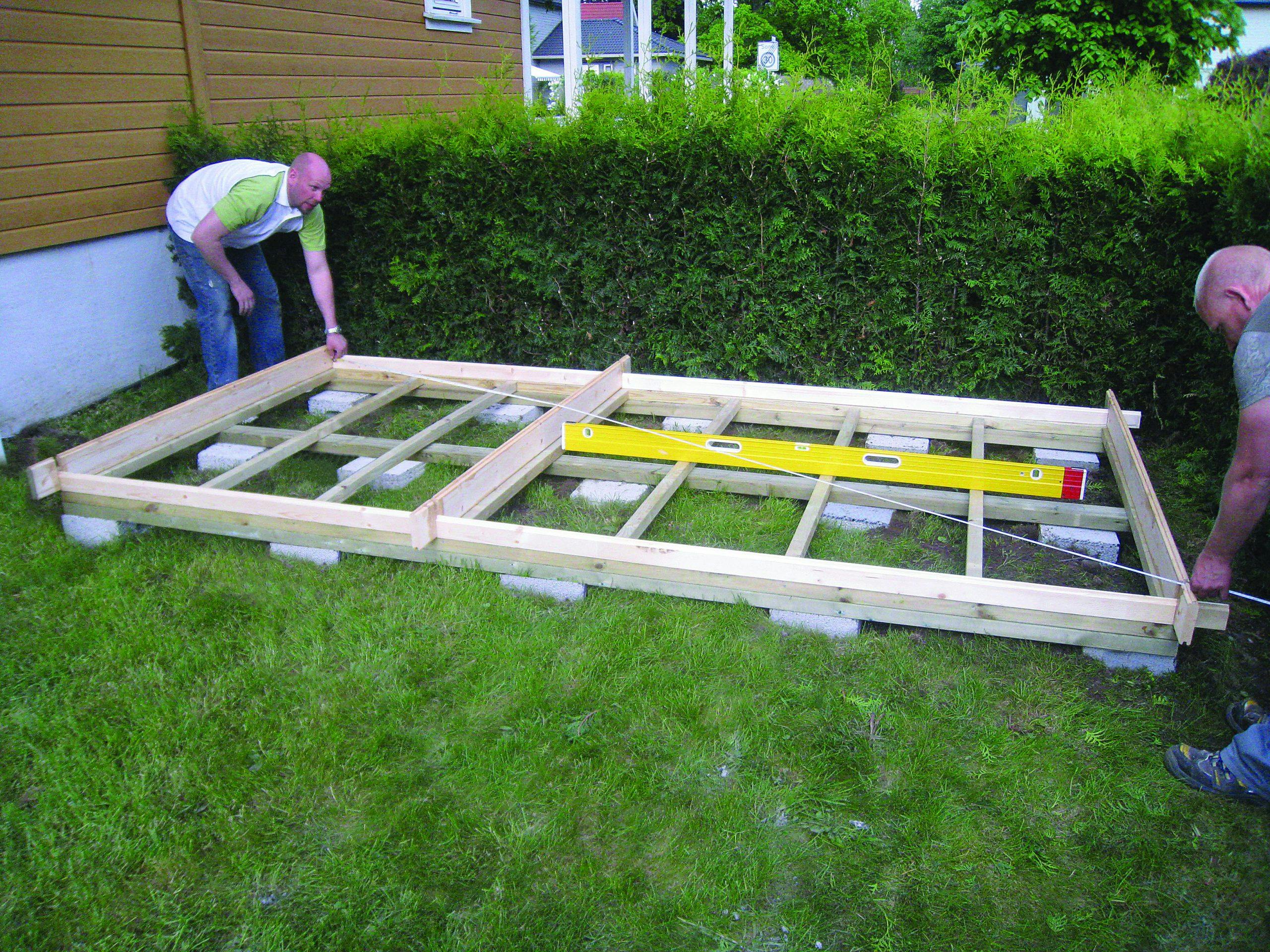 To menn bygger fundament pÃ¥ gress i hage