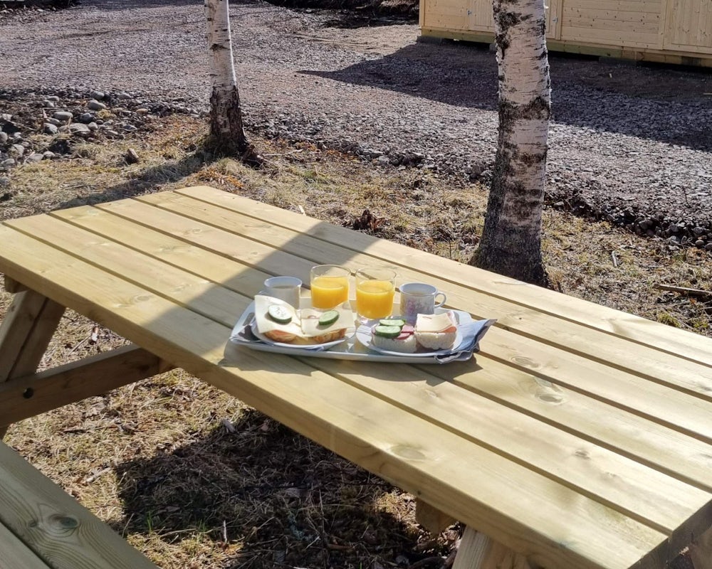 piknikbord frokostbrett satt frem på piknikbenk med bord