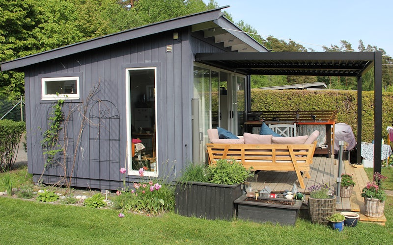 Kolonihage side Vegghengt pergola sett fra siden på grått lite hus