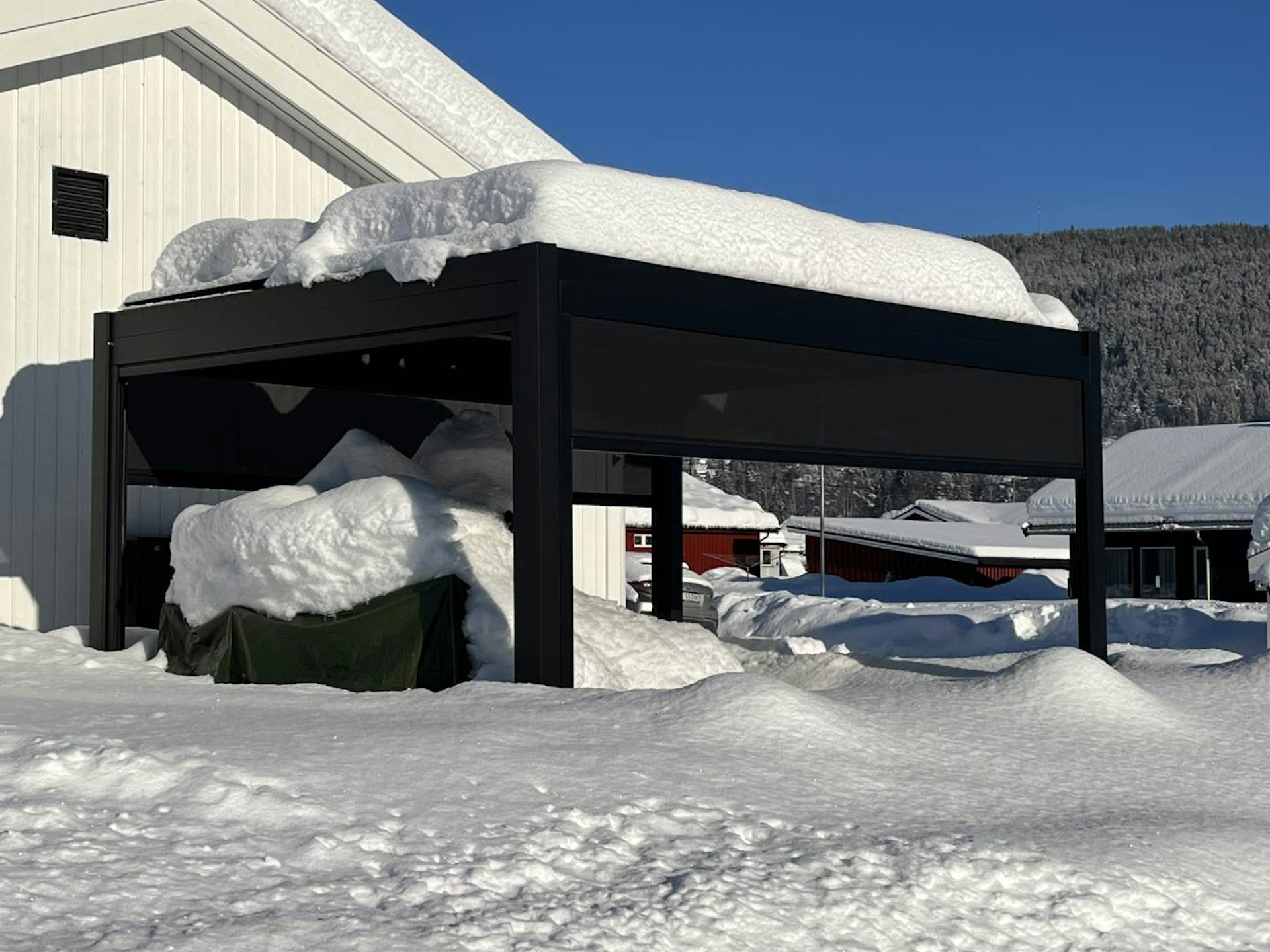 Sort pergola med snø på taket