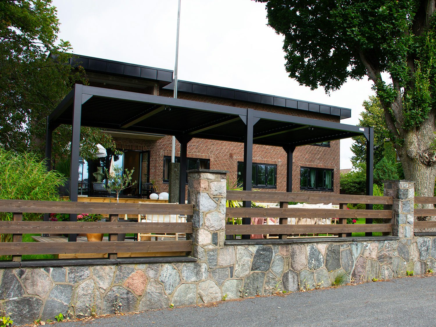 Pergola foran et teglsteinshus