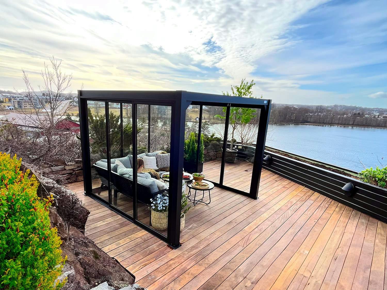 Pergola med skyvedører i glass på platting med utsikt over sjøen