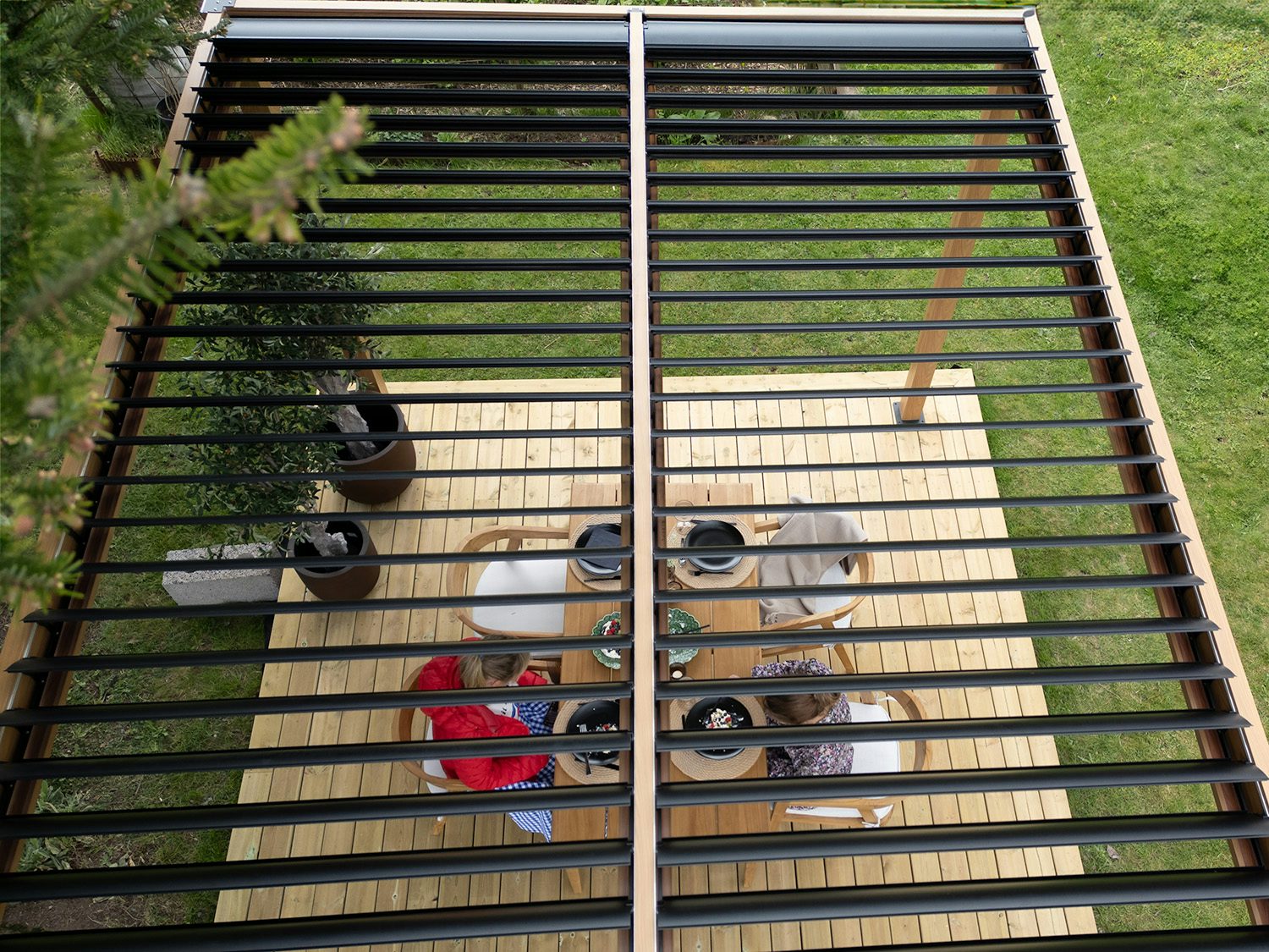 to som spiser kake gjennom lameller på en pergola. foto